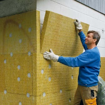 Facadeisolering: Isoleringen trykkes fast Facadeisolering: Isoleringen trykkes fast på væggen